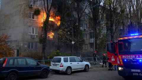 Feuerwehrleute arbeiten daran, ein Feuer in einem Wohnhaus zu löschen, das am 15. November 2022 in Kiew von einem russischen Raketenangriff getroffen wurde.