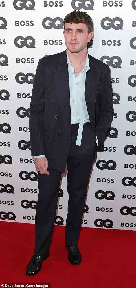 Smart: Paul cut a dapper figure in a black pinstripe suit which he wore with a light blue shirt and gold chain necklace