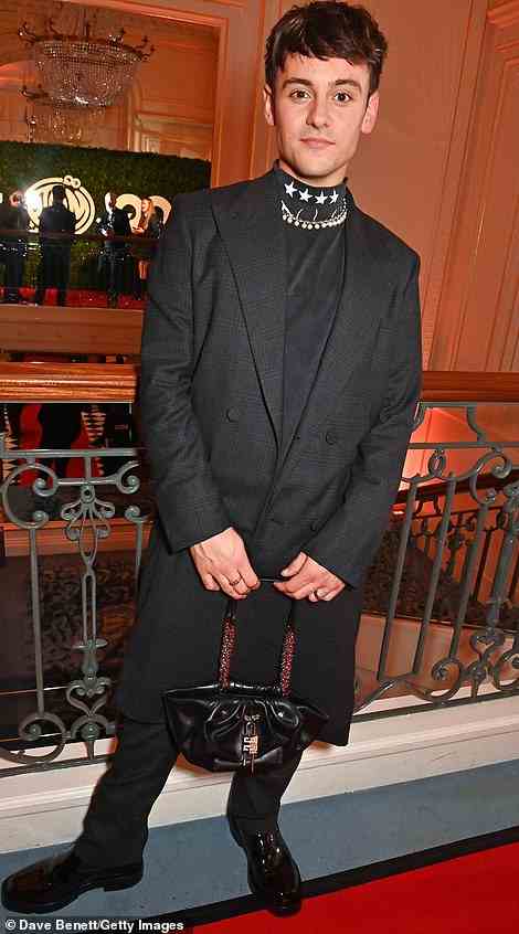 Edgy: He cut a quirky figure in his all-black ensemble, which he teamed with a black clutch bag and a beaded necklace