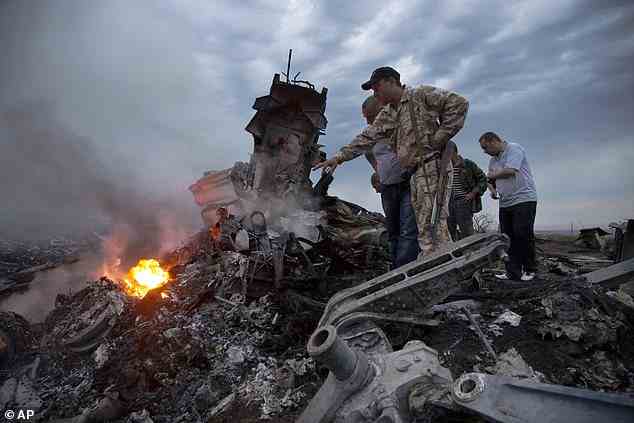 People inspect the crash site of a passenger plane near the village of Hrabove, Russian-controlled Donetsk region of Ukraine in July 2014