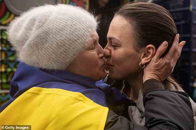 Oksana Shevluga (links) küsst ihre Tochter Nastia (rechts), die heute Morgen mit dem ersten Zug zurück zum Bahnhof Kherson kam