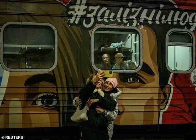Menschen in Kiew machen Selfies vor dem ersten Zug, der ins befreite Cherson fährt