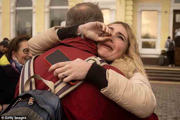 Vladimir (rote Jacke) wird von einem Freund der Familie umarmt, nachdem er in Cherson angekommen ist