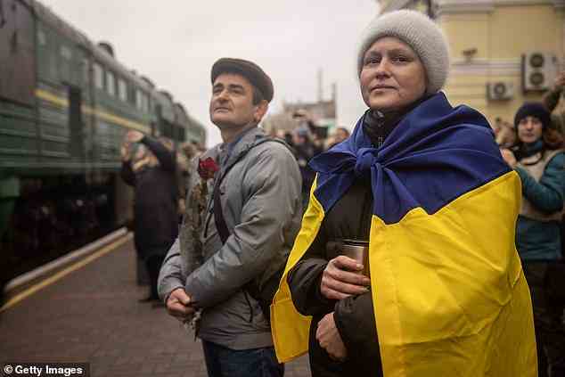 Mykola Desiatnikov und Oksana Shevluga warten auf dem Bahnsteig darauf, mit ihren Lieben wieder vereint zu werden