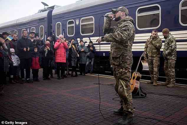 Der ukrainische Musiker Oleksandr Yarmak singt vor einer Menschenmenge auf dem Bahnsteig
