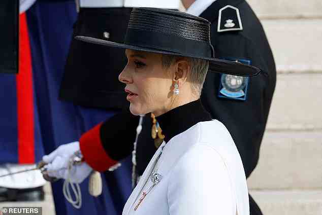 Sie vervollständigte ihr monochromes Ensemble mit einem schwarzen Hut mit breiter Krempe und einfachen Perlenohrringen.  Die Königin behielt ihr Make-up einfach für diesen Anlass