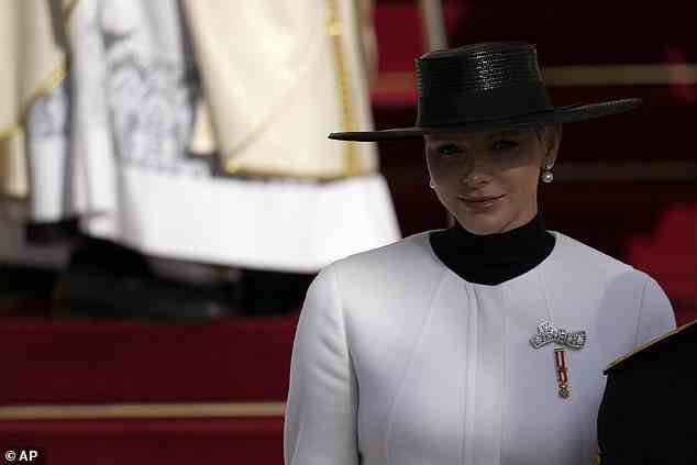 Prinzessin Charlene trug einen breitrandigen schwarzen Hut mit einem kontrastierenden hellweißen Hosenanzug