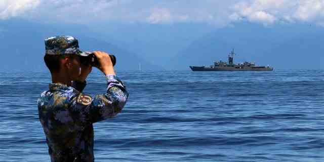 Ein Mitglied der Volksbefreiungsarmee schaut am Freitag, den 5. August 2022, während Militärübungen durch ein Fernglas, während Taiwans Fregatte Lan Yang am Heck zu sehen ist.