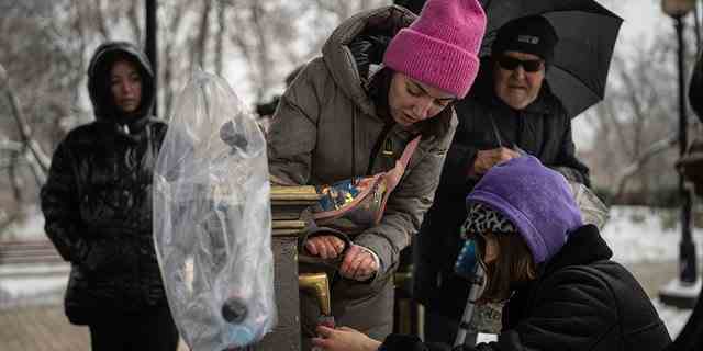 Menschen sammeln Wasser in Kiew, Ukraine, Donnerstag, 24. November 2022. 