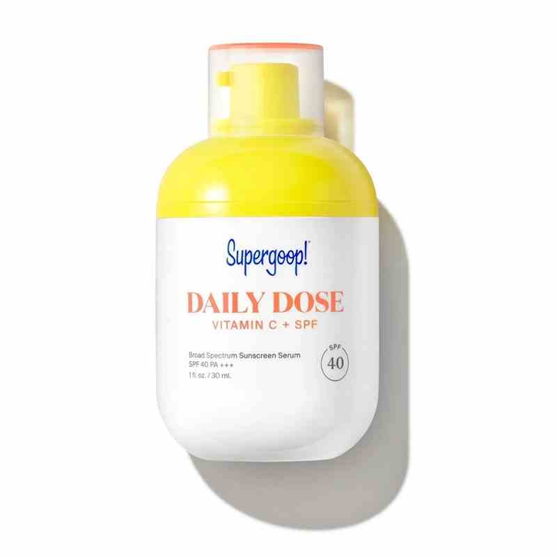 Eine weiße Flasche mit gelber Pumpe und durchsichtiger Kappe des Supergoop Daily Dose Vitamin C + SPF 40 Serums auf weißem Hintergrund