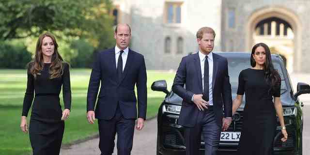Meghan Markle und Prinz Harry hielten Händchen, als sie mit Prinz William und Kate Middleton auf Schloss Windsor spazieren gingen, um Blumen und Hommagen an Königin Elizabeth II. Zu sehen.