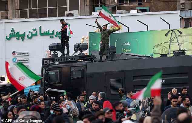 Mitglieder der iranischen Bereitschaftspolizei schwenken Nationalflaggen, während Fans auf die Straße gehen, um den Sieg ihrer Fußballmannschaft gegen Wales zu feiern