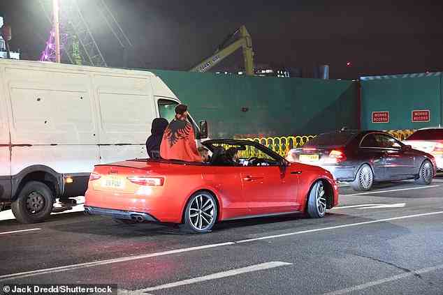 Albaner fahren auf dem Rücksitz eines Audi-Cabriolets und feiern in London die Unabhängigkeit ihres Landes