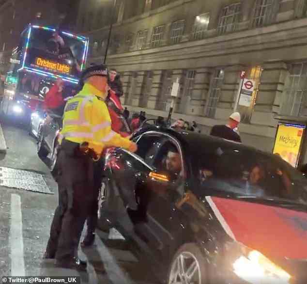 Die Polizei spricht mit albanischen Autofahrern, als sie am Montagabend im Zentrum von London feierten