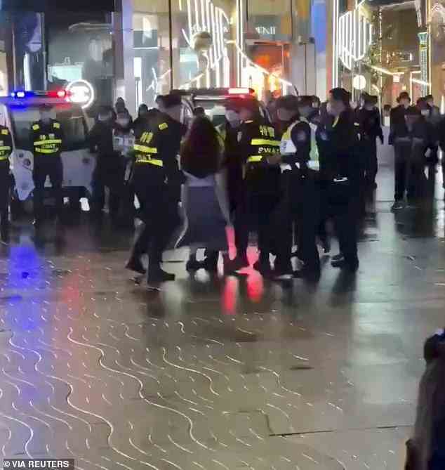 Dramatic video shows a woman screaming as she is arrested by six police officers and dragged away from a main square in Hangzhou, as Chinese officials sought to crack down on protesters in the city