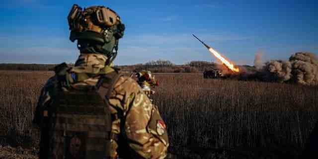 Ein ukrainischer Soldat beobachtet einen selbstfahrenden 220-mm-Mehrfachraketenwerfer "Büro" Feuer auf russische Stellungen an der Frontlinie in der Ostukraine am 29. November 2022, inmitten der russischen Invasion in der Ukraine. 