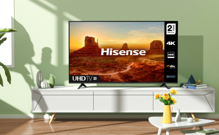Ein 70-Zoll-4K-Fernseher der Klasse A6G von Hisense auf einer weißen Medienkonsole.  Sonnenlicht und Schatten werden über das Wohnzimmer geworfen.