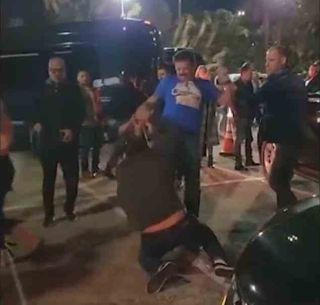 Das Video beginnt damit, dass der Mann im blauen Hemd auf das Opfer einschlägt und es zurück auf den Boden tritt, als es versucht aufzustehen