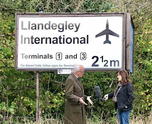 Eine Werbetafel, die auf Llandegley International zeigt, ist zu einem Wahrzeichen geworden, seit sie erstmals 2002 von Nicholas Whitehead (Bild links) in der Nähe des ländlichen Dorfes Powys aufgestellt wurde