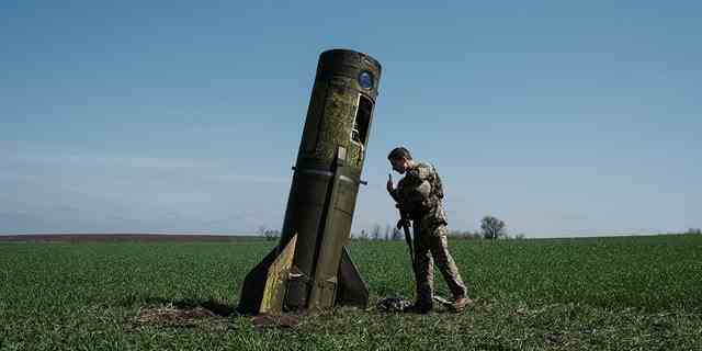 Ein ukrainischer Soldat betrachtet die Trägerstufe einer russischen ballistischen Rakete, die am 25. April 2022 inmitten der russischen Invasion in der Ukraine auf ein Feld in Bohodarove in der Ostukraine fiel.