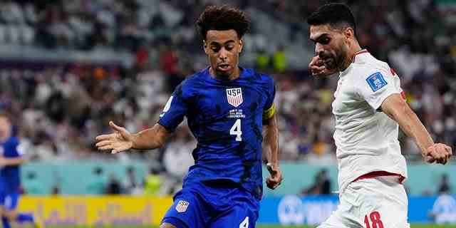 Tyler Adams aus den Vereinigten Staaten, links, versucht, den Iraner Ali Karimi während des WM-Spiels der Gruppe B im Al-Thumama-Stadion in Doha, Katar, am 29. November 2022 zu blockieren.