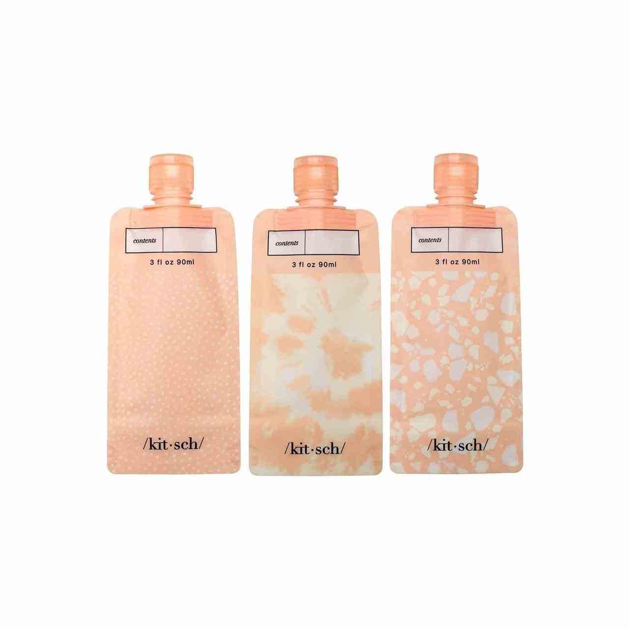 Kitsch nachfüllbare Reiseflaschen drei pfirsichfarbene Flaschen auf weißem Hintergrund