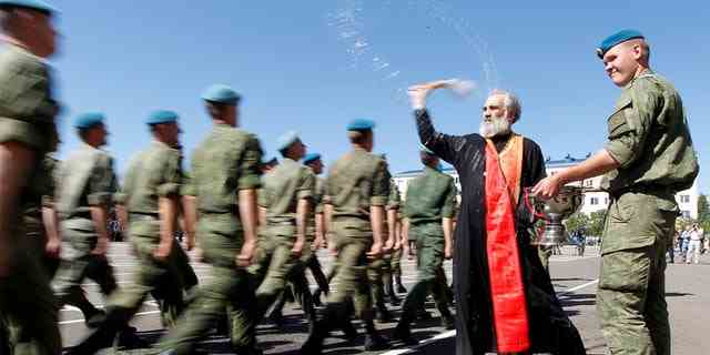 Ein orthodoxer Priester segnet russische Fallschirmjäger, die während der Feierlichkeiten zum Tag der Fallschirmjäger 2017, dem jährlichen Feiertag der russischen Luftlandetruppen, bei ihrer Militäreinheit in der südlichen Stadt Stawropol, Russland, marschieren. 
