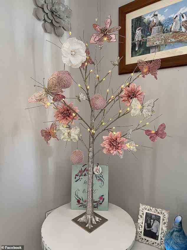 Ein dritter Käufer entschied sich für etwas Fröhlicheres mit einem einfachen, eleganten „Zweigbaum“ von Kmart.  Der silberstämmige Baum hat goldene Lichter an den Spitzen zusammen mit wunderschönen rosa und weißen Blumen, Ornamenten und Schmetterlingen (im Bild)