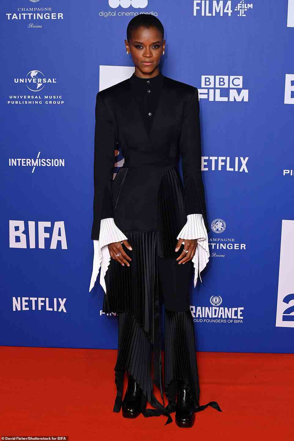 Edgy style credentials: Letitia Wright showed off her edgy sense of style as she wore a black dress with crimped white cuffs