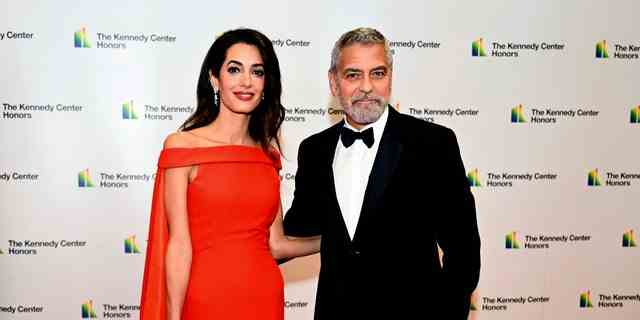 George Clooney und Amal Clooney posieren vor der Medaillon-Zeremonie auf dem roten Teppich.