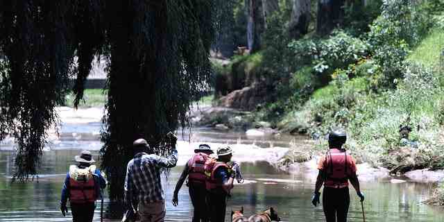 Rettungskräfte durchsuchen am Sonntag, 4. Dezember 2022, die Gewässer des Jukskei-Flusses in Johannesburg. 