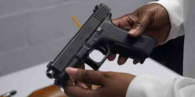 Eine Pistole aus einer Sammlung illegaler Waffen wird während einer Waffenrückkaufveranstaltung in Brooklyn, NY, am 22. Mai 2021 überprüft.