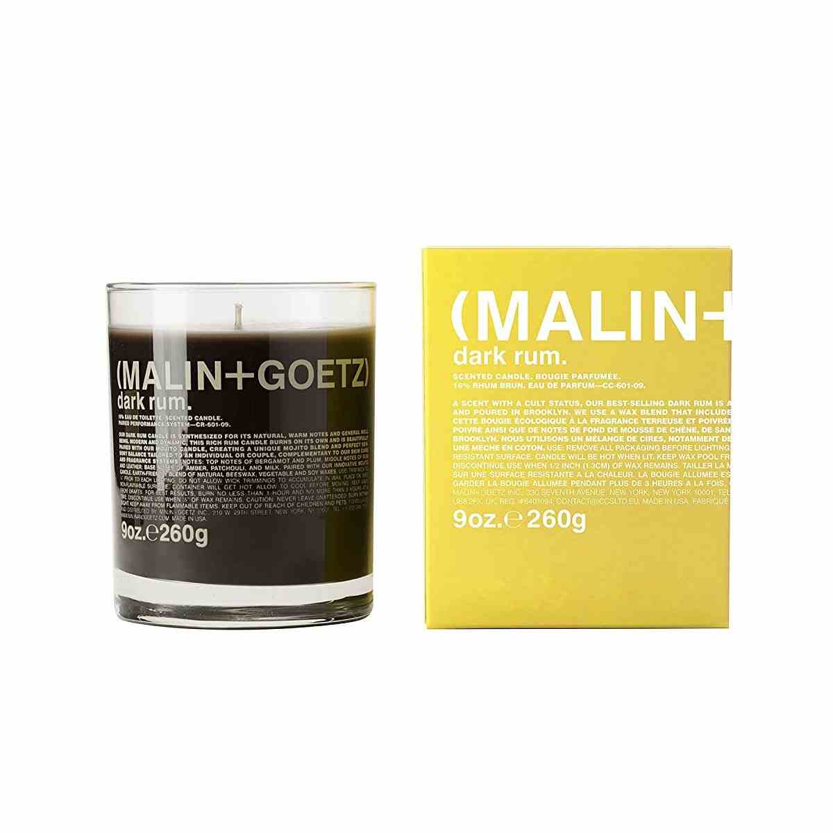 Malin + Goetz Votivkerze dunkelbraune Kerze in transparentem Glas mit gelber Box auf weißem Hintergrund
