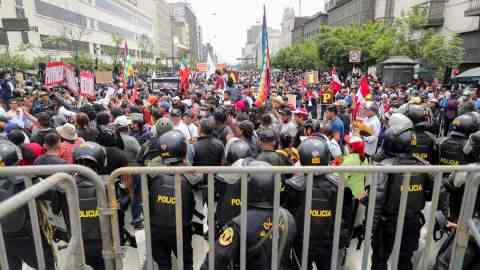 Polizisten stehen Wache, als sich Menschen vor dem peruanischen Kongress versammeln, nachdem Präsident Pedro Castillo angekündigt hatte, ihn am 7. Dezember aufzulösen.