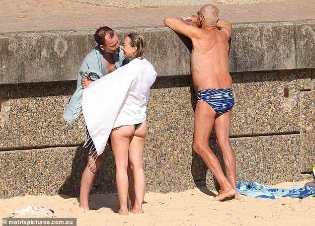 Nothing to see here: An elderly sunbather looks away while Galafassi and Ms Egan embrace