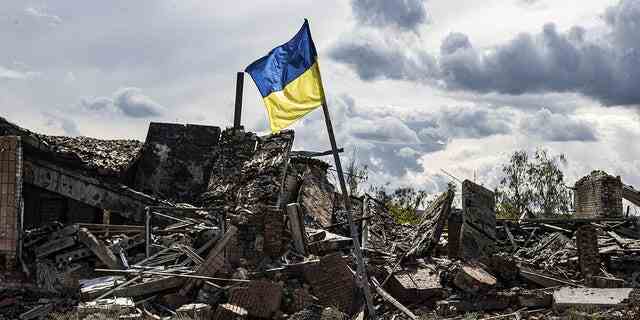 Eine ukrainische Flagge weht in einem schwer beschädigten Wohngebiet im Dorf Dolyna in der Oblast Donezk, Ukraine, nach dem Abzug russischer Truppen.