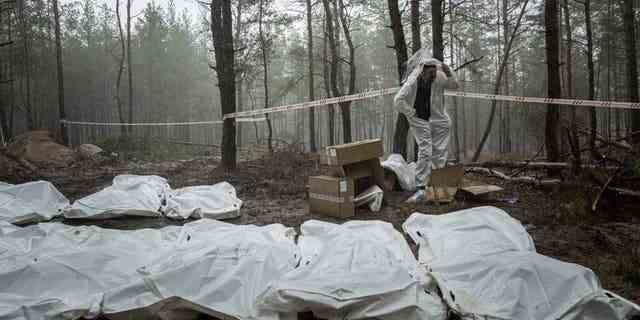 Säcke mit Leichen werden während der Exhumierung im kürzlich zurückeroberten Gebiet von Izium, Ukraine, Freitag, 16. September 2022, gesehen. Die ukrainischen Behörden entdeckten eine Massengrabstätte in der Nähe der zurückeroberten Stadt Izium, die Hunderte von Gräbern enthielt. 
