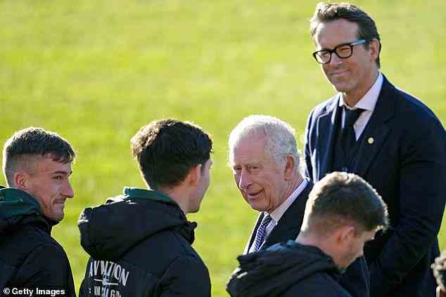 King Charles III und Co-Eigentümer Wrexham AFC Ryan Reynolds sprechen mit Spielern während ihres Besuchs bei Wrexham AFC