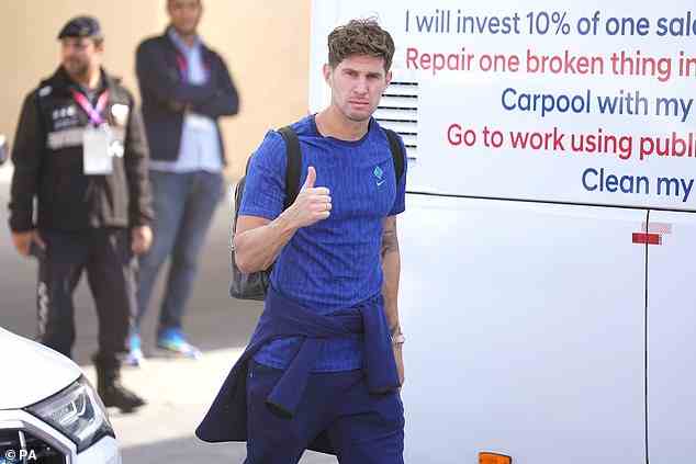 John Stones gives a thumbs up while looking serious as he heads home with the team