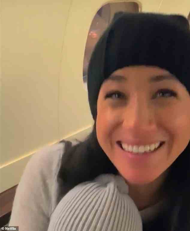 A blink-and-you'll-miss-it-clip shows Meghan beaming at the camera in a home movie with one of their children