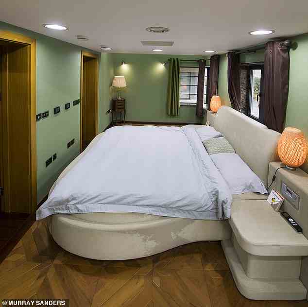 Ein avantgardistisches Schlafzimmer verfügt über Parkettboden, ein rundes Bett mit eingebauten Nachttischen und geflochtenen Lampen