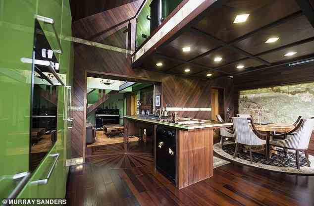Die Küche der Unterkunft umfasst Holzböden und -wände aus Parkett sowie rautenförmige Scheinwerfer und grüne Kücheneinheiten