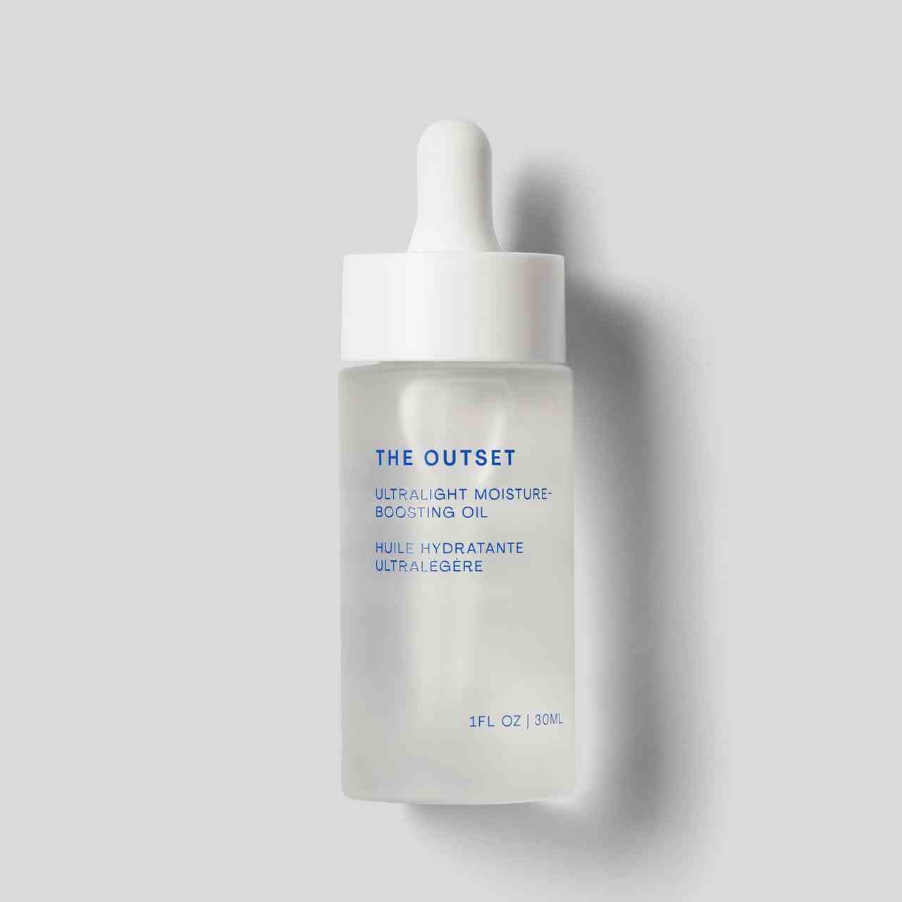 The Outset Ultralight Moisture-Boosting Oil klare Serumflasche auf grauem Hintergrund
