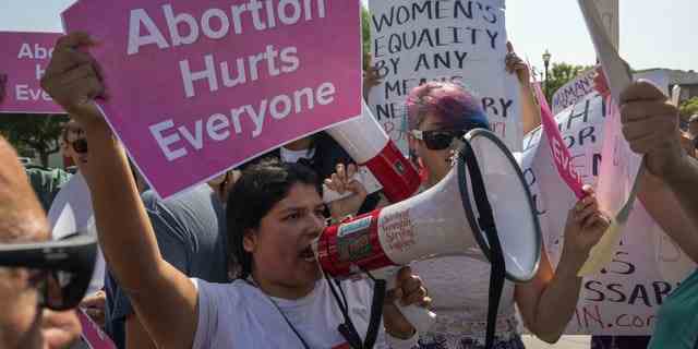 Eine Gruppe von Pro-Life-Demonstranten stürzt am 8. Oktober 2022 auf der Women's March Action Rally for Reproductive Rights auf dem Mariachi Plaza in Los Angeles ab.