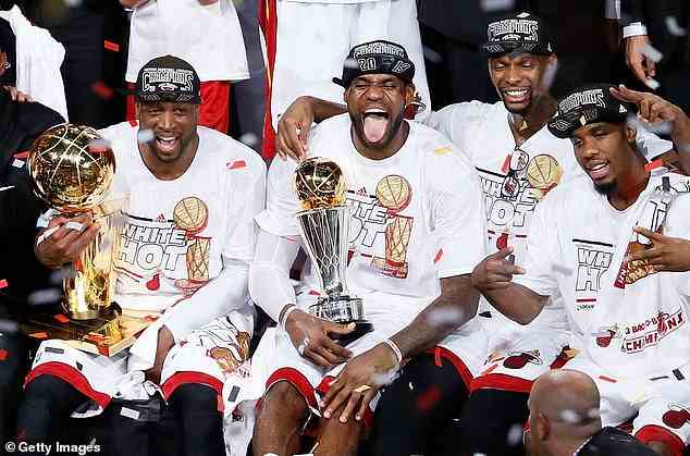 Dwyane Wade (ganz links), LeBron James (Mitte) und Chris Bosh feiern, nachdem sie die San Antonio Spurs mit 95:88 besiegt und das siebte Spiel der NBA Finals 2013 gewonnen haben.  Das Trio hatte 2012 auch die Larry O'Brien Trophy gewonnen