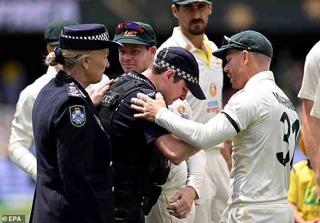 Warner tröstet Polizisten vor dem Spiel als Teil einer Hommage an die getöteten Polizeibeamten von Queensland in dieser Woche