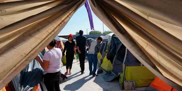 Migranten gehen am Donnerstag, 15. Dezember 2022, an ihren Zelten in der Notunterkunft Senda de Vida 2 in Reynosa, Mexiko, vorbei. 