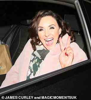Glam: Shirley Ballas bundled up in a pink fluffy coat which she wore over a green floral blouse while flashing a peace sign for the camera