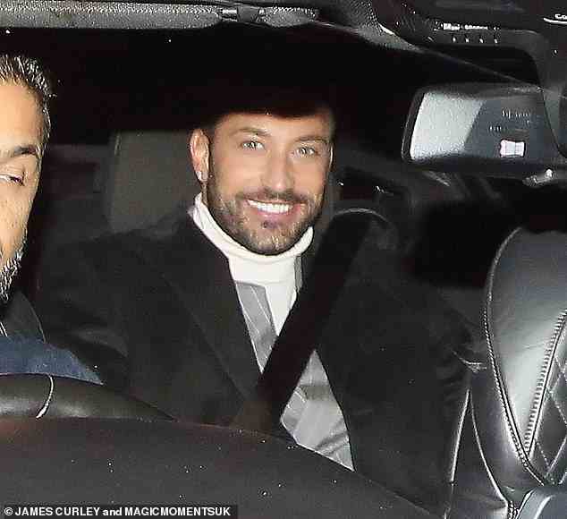 Looking good: Giovanni Pernice cut a dapper figure in a white turtleneck top and a black coat