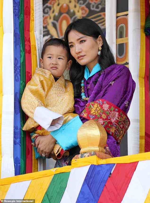 Prinz Ugyen, der 2020 geboren wurde, trug ein goldenes Kleid und schmiegte sich bequem in die Arme seiner Mutter, während er das Ereignis wachsam im Auge behielt
